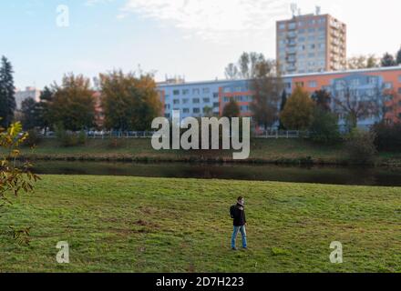 Luftaufnahme junger kaukasischer Mann, der in der herbstlichen Landschaft in der Nähe spazierengeht Moldau mit Gesichtsmaske und Rucksack Stockfoto