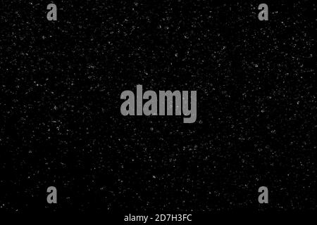 Chaotisches weißes Bokeh auf schwarzem Hintergrund. Lichtflecken Textur, Abstraktion. Fallender Schnee. Sternenhimmel. Stockfoto