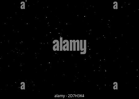 Chaotisches weißes Bokeh auf schwarzem Hintergrund. Lichtflecken Textur, Abstraktion. Fallender Schnee. Sternenhimmel. Stockfoto