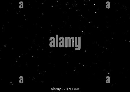 Chaotisches weißes Bokeh auf schwarzem Hintergrund. Lichtflecken Textur, Abstraktion. Fallender Schnee. Sternenhimmel. Stockfoto
