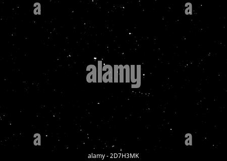 Chaotisches weißes Bokeh auf schwarzem Hintergrund. Lichtflecken Textur, Abstraktion. Fallender Schnee. Sternenhimmel. Stockfoto