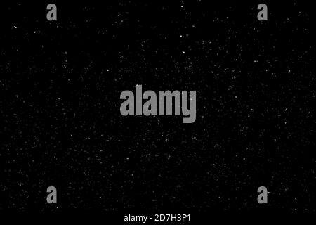 Chaotisches weißes Bokeh auf schwarzem Hintergrund. Lichtflecken Textur, Abstraktion. Fallender Schnee. Sternenhimmel. Stockfoto