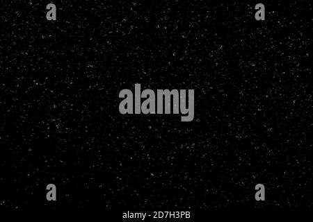 Chaotisches weißes Bokeh auf schwarzem Hintergrund. Lichtflecken Textur, Abstraktion. Fallender Schnee. Sternenhimmel. Stockfoto