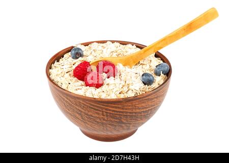 Frische Heidelbeeren, Himbeeren, Waffelplätzchen und Haferflocken in einer Schüssel mit einem Holzlöffel isoliert auf weißem Hintergrund. Stockfoto