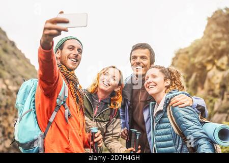 Glückliche Freunde, die mit der mobilen Smartphone-Kamera ein Foto-Selfie machen Berge - Gruppe junge Menschen Trekking und Spaß mit Neue Technologietrends Stockfoto