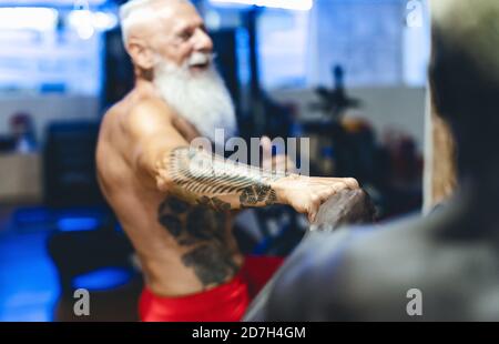 Athleten mit unterschiedlichen Alter und Rennen tun Fahrrad-Übungen in Gym - Fit Menschen Training auf dem Fahrrad-Maschine in Gesundheit Wellness-Center Stockfoto
