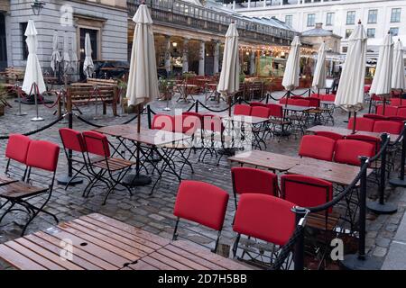 Leere Sitzplätze erwarten Bar- und Restaurantgäste an einem regnerischen und nassen Tag in Covent Garden während der zweiten Welle der Coronavirus-Pandemie und wenn die Hauptstadt am 21. Oktober 2020 von der Regierung als Tier-2-Beschränkung in London, England, ausgewiesen wird. Stockfoto