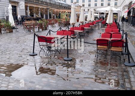 Leere Sitzplätze erwarten Bar- und Restaurantgäste an einem regnerischen und nassen Tag in Covent Garden während der zweiten Welle der Coronavirus-Pandemie und wenn die Hauptstadt am 21. Oktober 2020 von der Regierung als Tier-2-Beschränkung in London, England, ausgewiesen wird. Stockfoto