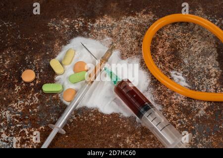 Spritze und Drogen auf schmutzigem rostigen Hintergrund. Injektionsspritze. Sucht Stockfoto