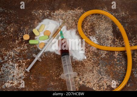 Spritze und Drogen auf schmutzigem rostigen Hintergrund. Injektionsspritze. Sucht Stockfoto