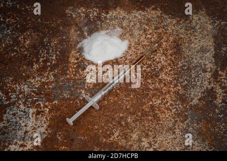 Spritze und Drogen auf schmutzigem rostigen Hintergrund. Injektionsspritze. Sucht Stockfoto