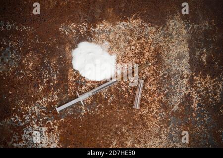 Spritze und Drogen auf schmutzigem rostigen Hintergrund. Injektionsspritze. Sucht Stockfoto