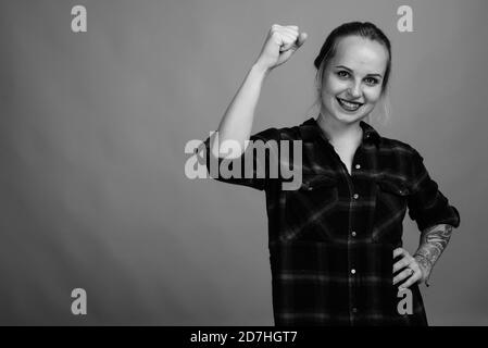 Junge schöne Frau mit blonden Haaren gegen grauer Hintergrund Stockfoto