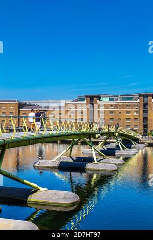 Zu den Leuten, die die North Dock Footbridge zum West India Quay, Canary Wharf, London, Großbritannien laufen Stockfoto