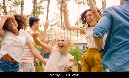 Familie und Freunde tanzen gemeinsam auf der Gartenparty-Feier. Junge und ältere Menschen haben Spaß an einer sonnigen Sommertag-Disco. Stockfoto