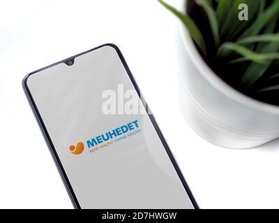 LOD, Israel - 8. Juli 2020: Moderner minimalistischer Büroarbeitsplatz mit schwarzem Smartphone mit Meuhedet Health Services App Launch Screen mit Logo Stockfoto