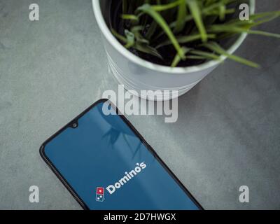 LOD, Israel - 8. Juli 2020: Moderner minimalistischer Büroarbeitsplatz mit schwarzem Smartphone mit Domino's Pizza Israel App Launch Screen mit Logo auf Stockfoto