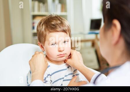 Kinderarzt palpates Mandeln und Lymphknoten bei einem Kind mit Tonsillitis Stockfoto