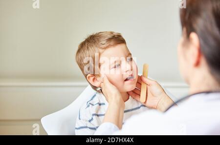 Kinderarzt palpates Mandeln und geschwollene Lymphknoten bei Kindern mit Tonsillitis Stockfoto