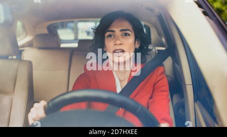 Porträt der Angst schöne junge Frau Fahren Auto Suburban Bereich. Kameraaufnahme aus dem vorderen Windschutz. Stockfoto