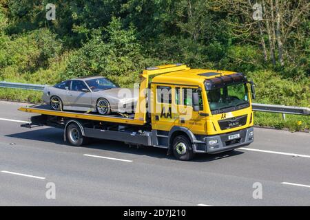 Teilweise restaurierter Triumph TR7 Oldtimer auf AA Autotransporter. Pannenrückgewinnung am Straßenrand; Transportfahrzeuge, LKW, Transport, LKW, Fahrzeugzustellung, gewerbliche Transportindustrie, auf der M6 in Manchester, Großbritannien Stockfoto