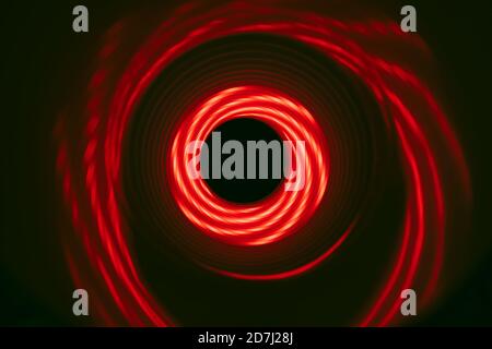 Schöner abstrakter Wirbeltunnel mit rotem Neonlicht auf einem Hintergrund Pttern strukturiert für deisgn. Stockfoto
