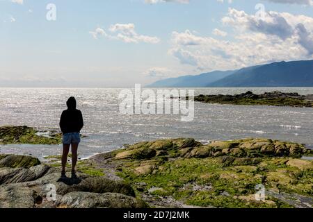 Landschaft, St. Lawrence River, in Richtung der Insel "L'Isle-aux-Coudres", Quebec, Kanada. Jemand, allein, von hinten betrachtet, die Stockfoto