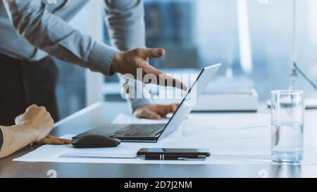 Nahaufnahme der anonymen Geschäftsfrau und Geschäftsmann diskutieren Projekt und mit Laptop-Computer, gestikulieren und zeigen auf den Bildschirm. Stockfoto