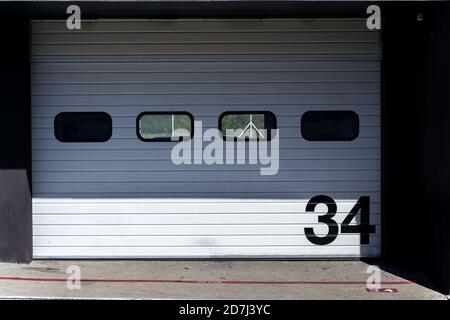 Weiße Metall-Garage mit großer schwarzer Zahl vor der Tür, sonniger Sommertag, Kopierplatz Stockfoto