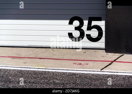 Weiße Metall-Garage mit großer schwarzer Zahl vor der Tür, sonniger Sommertag, Kopierplatz Stockfoto