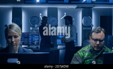 Regierung Cybersecurity Agency Profis, die auf Personal Computer in Zusammenarbeit mit Armee. Spezialisten, die an Computern im System arbeiten Stockfoto