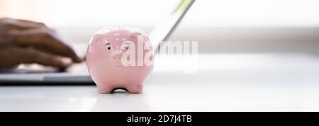 Sparen Sie Geld Online Mit Bank Piggy Und Laptop-Computer Stockfoto