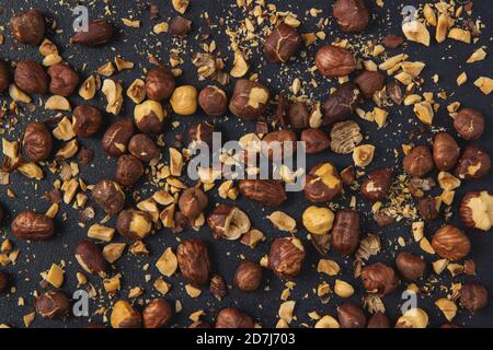 Hintergrundbild von gerösteten Haselnüssen isoliert auf dem dunklen Hintergrund. Geröstete Haselnüsse. Stockfoto