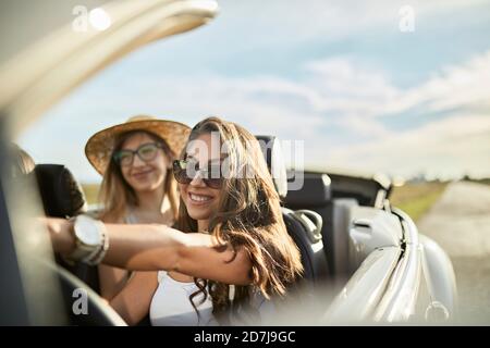 Lächelnde junge Freunde, die an einem sonnigen Tag reisen Stockfoto