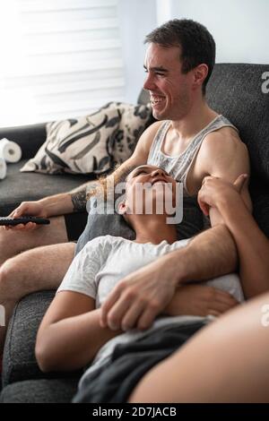 Lächelndes Paar, das sich zu Hause auf dem Sofa entspannt Stockfoto