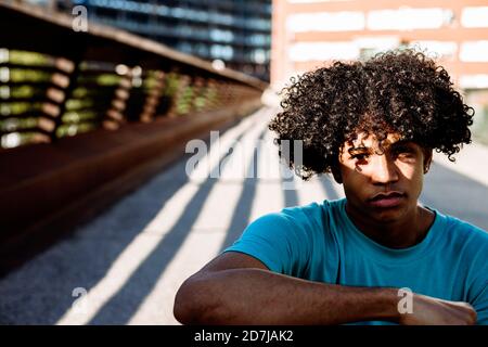 Betrachten junger Mann auf der Straße während sonnigen Tag sitzen Stockfoto