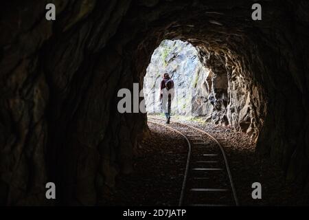 Männlicher Wanderer, der durch den Tunnel auf dem Tracciolino Trail geht Stockfoto