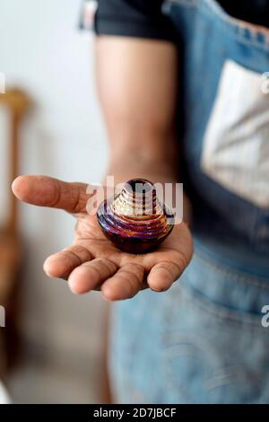 Nahaufnahme eines männlichen Töpfers mit Miniaturvase in der Werkstatt Stockfoto