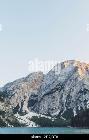 Blick auf Pragser Wildsee und schneebedeckten Berg gegen klaren Himmel, Dolomiten, Südtirol, Italien Stockfoto