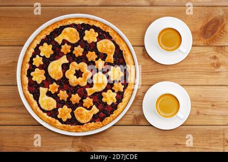 Hausgemachter Mürberbeerkuchen und zwei weiße Tassen Kaffee-Espresso auf Holztisch. Draufsicht. Stockfoto