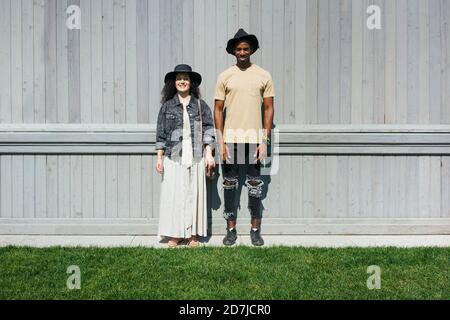Mann und Frau tragen einen Hut, der gegen die Wand steht Stockfoto