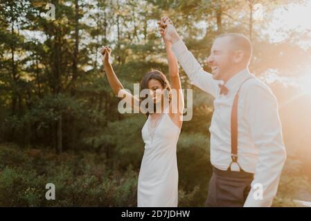 Glückliches Paar tanzt im Wald während des Sonnenuntergangs Stockfoto