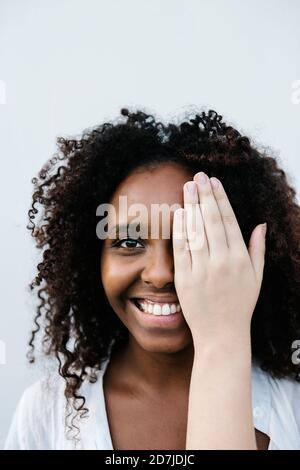 Hand bedeckendes Gesicht einer lächelnden Frau Stockfoto