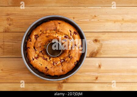 Frisch gebackener hausgemachter Himbeerkuchen in einer runden Metall-Backform auf Holztisch. Draufsicht. Copyspace. Stockfoto