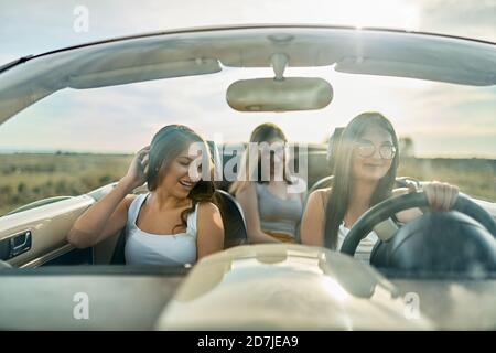 Freunde, die Spaß haben, während der Reise in Cabrio Auto für die Straße Reise Stockfoto