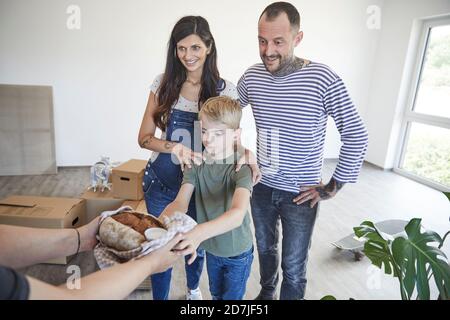 Zugeschnittenes Bild von Frau Hand kam mit Essen für die Familie Beim Umzug in neues Haus Stockfoto