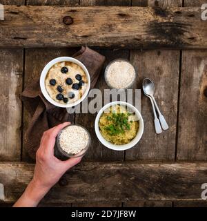 Zwei Schüsseln mit süßem und herzhaftem Brei und Hand Reife Frau Abholung kleine Schüssel Hafer Stockfoto