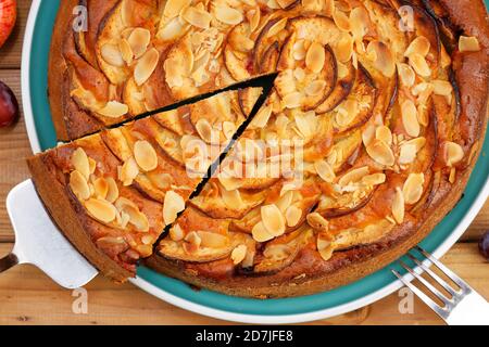 Nahaufnahme hausgemachter Kuchen mit Äpfeln und Pflaumen mit Mandelblüten. Draufsicht. Stockfoto