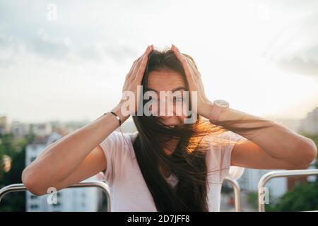 Aufgeregt junge Frau mit Kopf in den Händen genießen Riesenrad Bei Sonnenuntergang Stockfoto