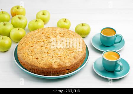 Hausgemachtes Gebäck. Apfelkuchen mit Mandelblüten und zwei Tassen Kaffee Espresso auf weißem Holztisch. Stockfoto